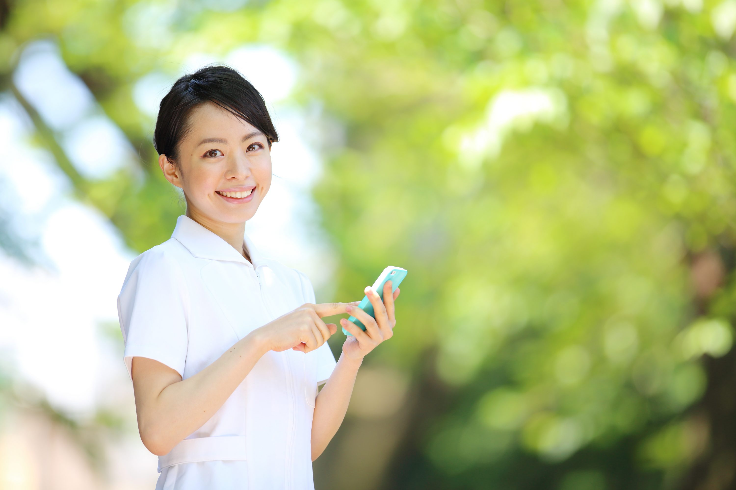 スマホをもって仕事を探す女性介護士