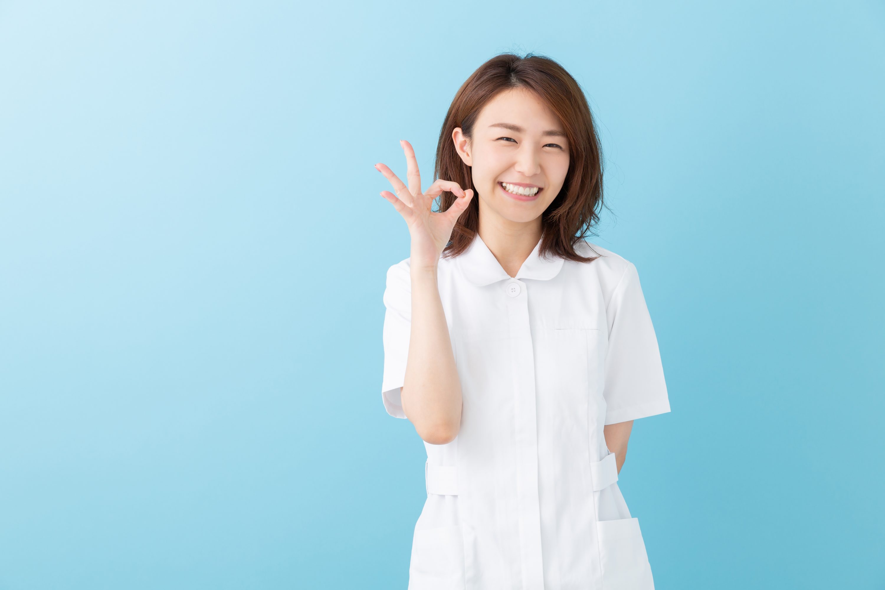 笑顔でOKサインを出す女性の画像