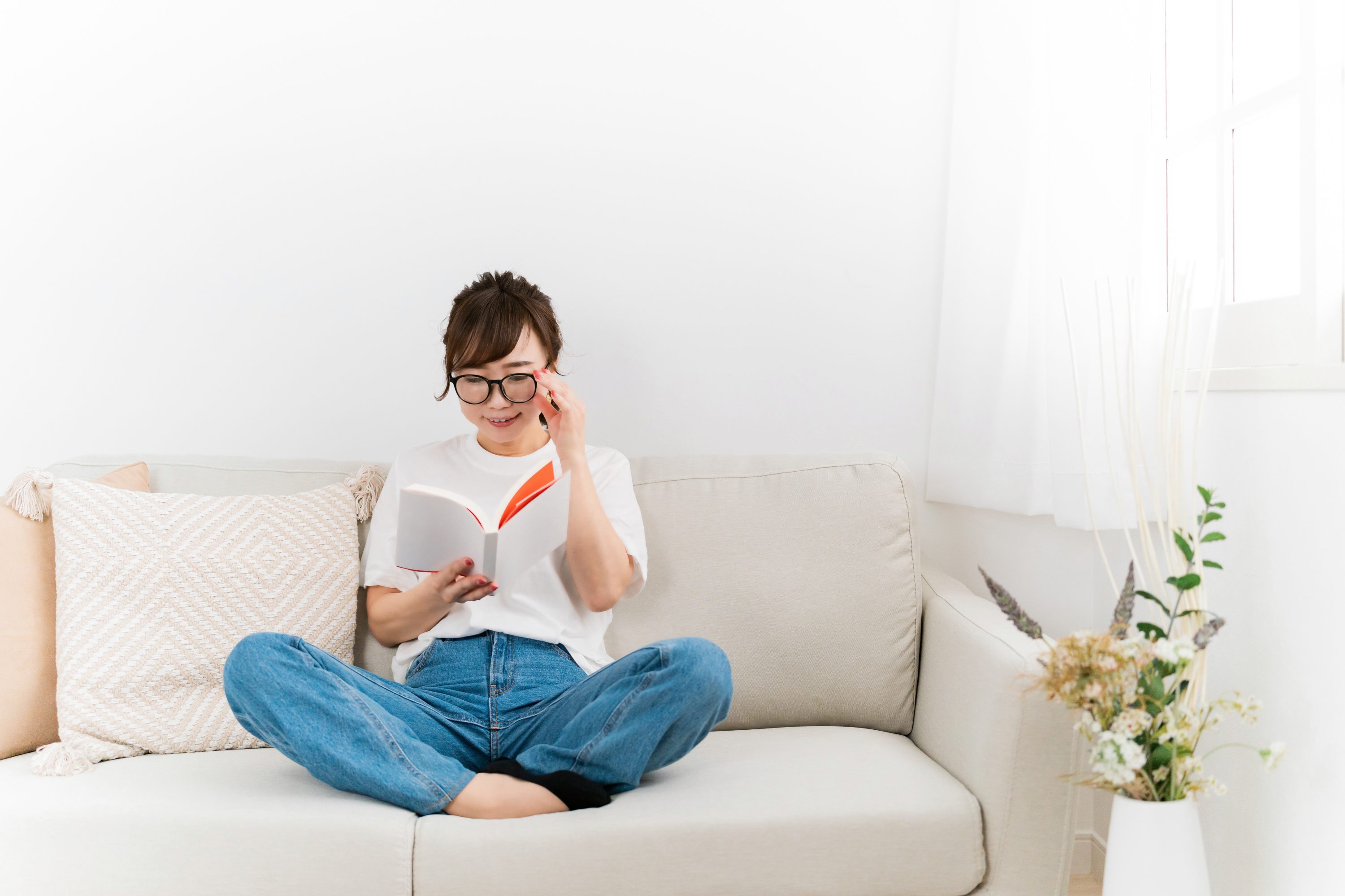ソファーの上でマンガを読む女性のイメージ