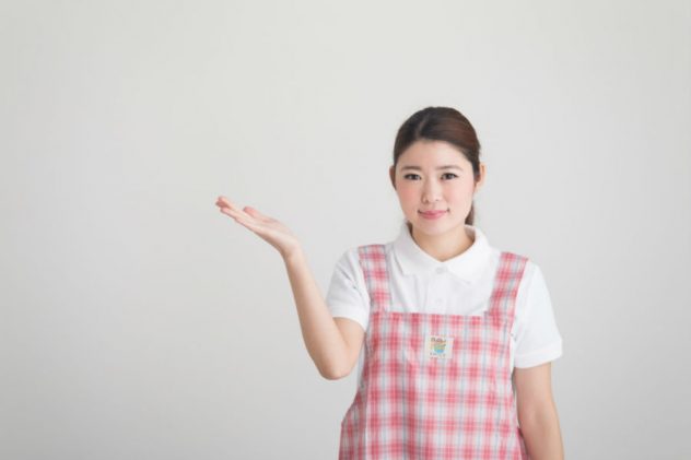 紹介するポーズを取っている介護士のイメージ