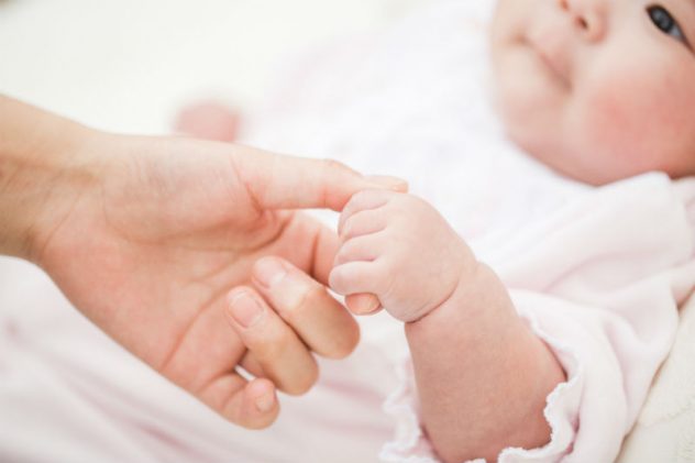 大人の手を握る赤ちゃんの画像