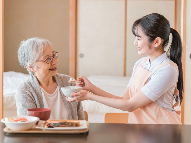 高齢者の食事介助をしている介護士のイメージ