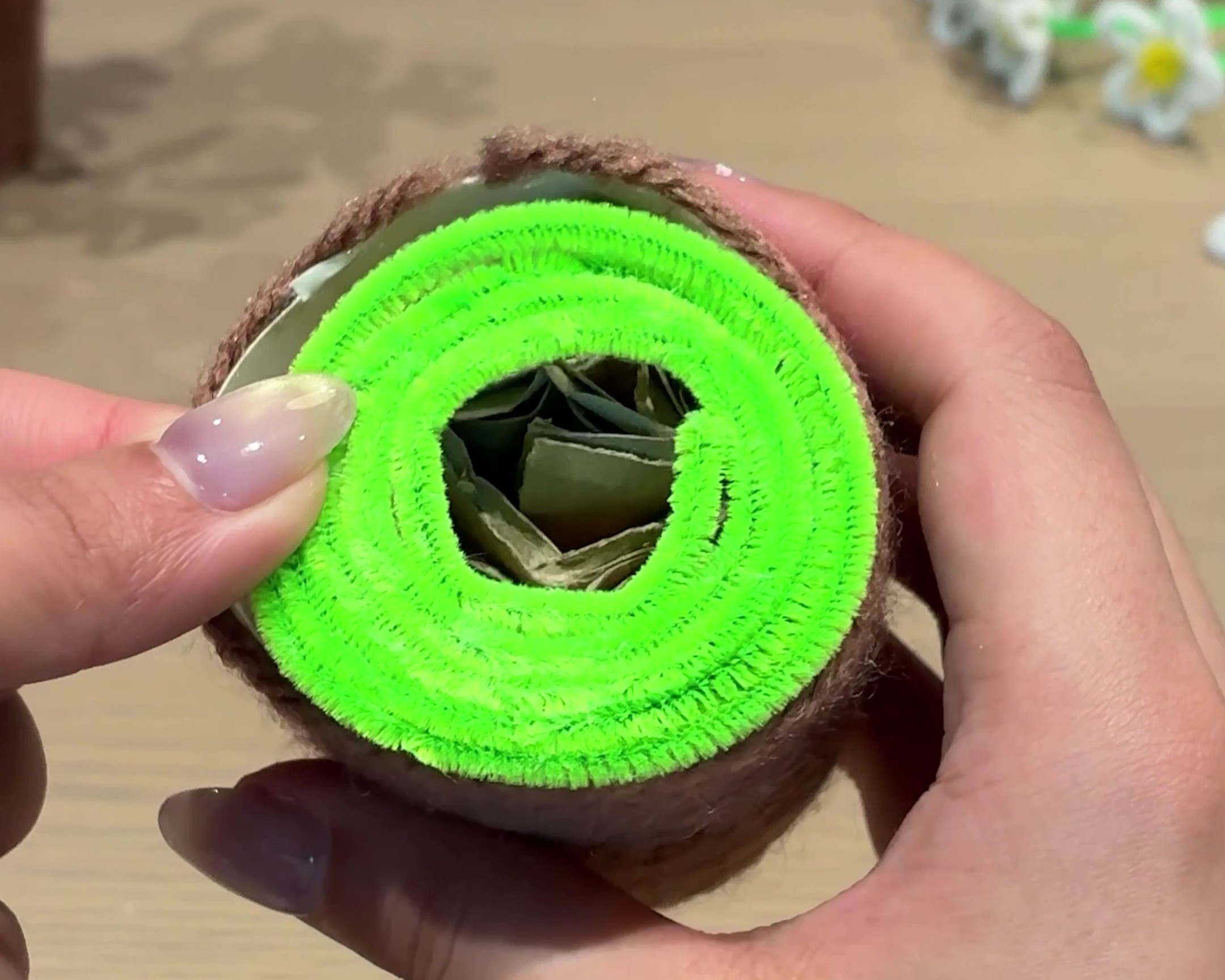 緑のモールを巻いたものを植木鉢の上に乗せる