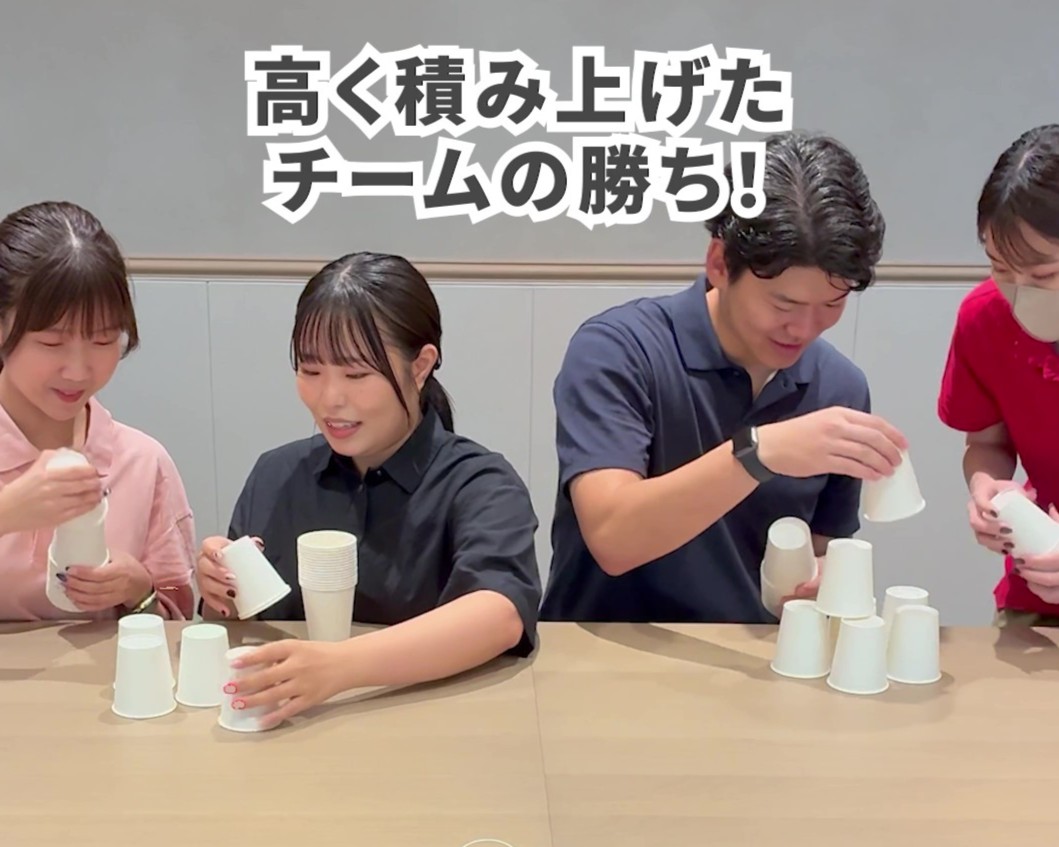 2チームに分かれて紙コップを積み上げている様子