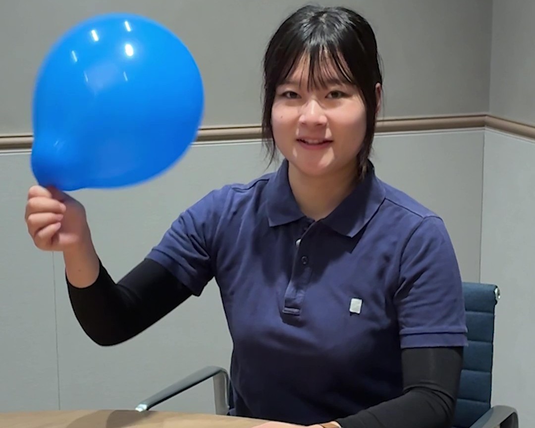 女性が青い風船を持っている画像