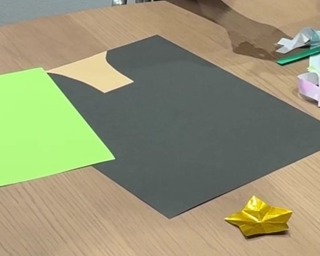 黒い画用紙にツリーの幹となる部分を切って貼り付けている様子