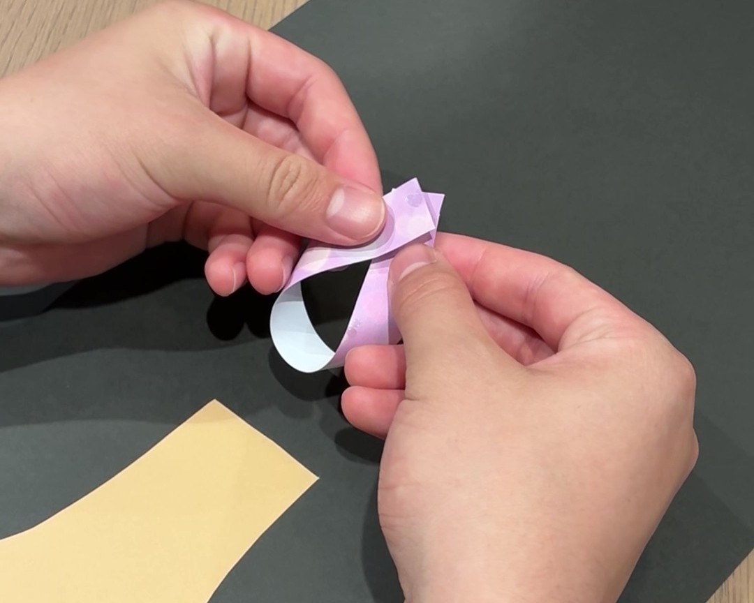 画用紙や折り紙を細長く切った紙でわっかを作っている様子